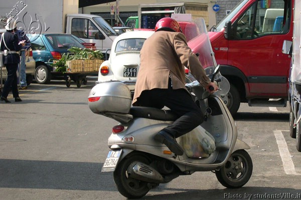 Vespa shopping (600Wx400H) - Jumping on the Vespa after the daily shopping at the market. It's by now lunch time! (Photo by Marco De La Pierre) 